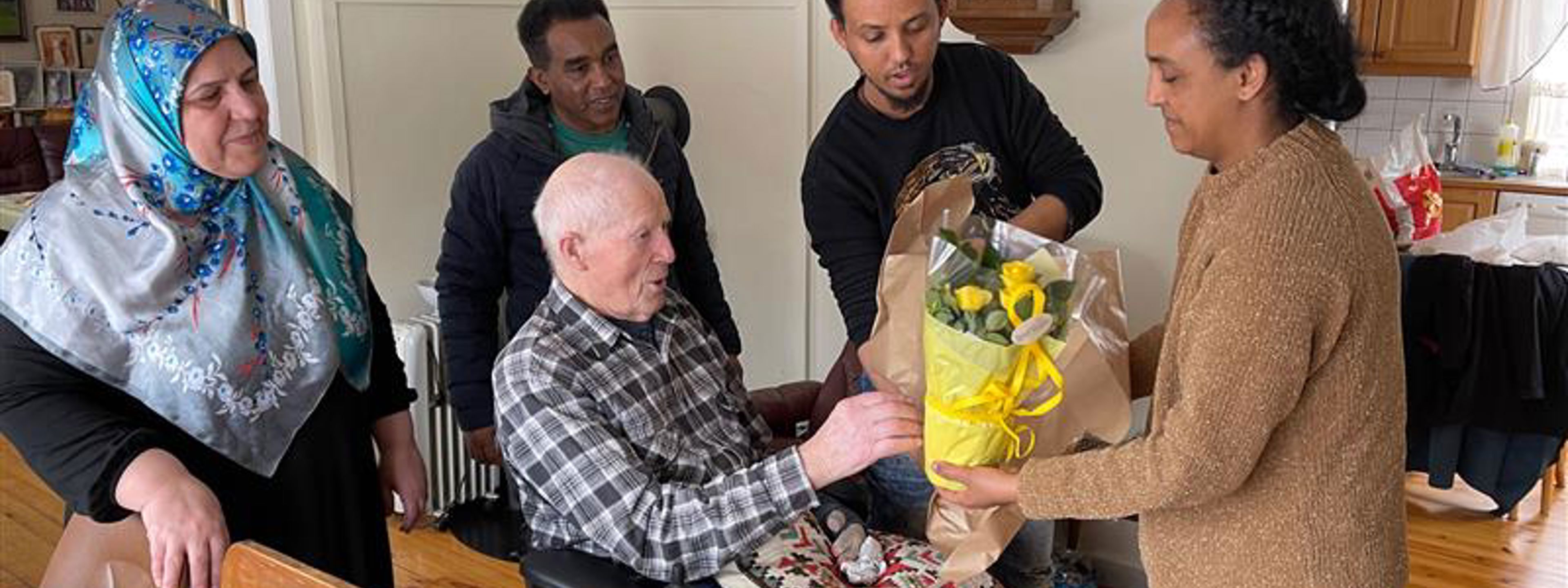 Elevar overrekkjer ein blomst til ein eldre mann