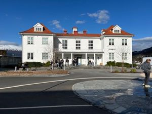 Gamlebygget ved Firda vgs, kvit trebygning med rødt tak, skuleplassen i front.
