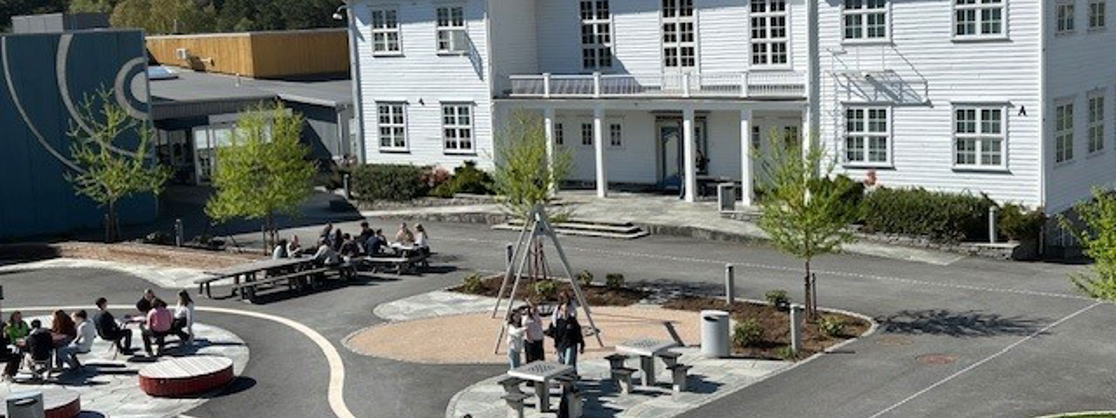 Gamlebygget på Firda vgs med skuleplassen i framgrunnen.