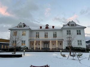 Gamlebygget på Firda vgs ( kvit trebygning) med snø i framgrunnen