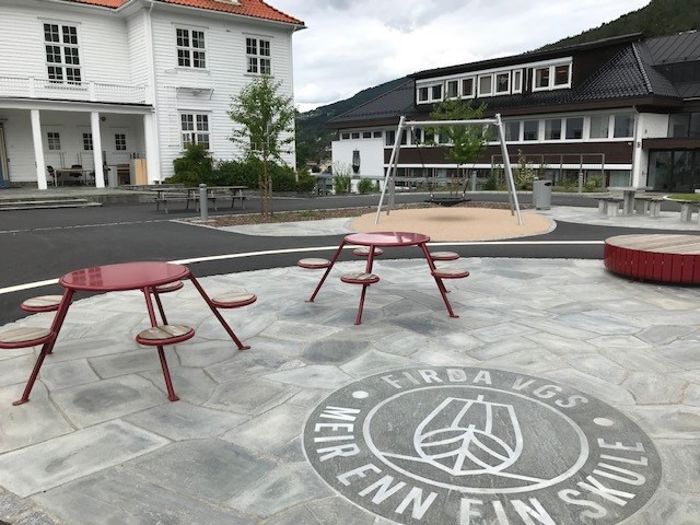 Gamlebygget og skuleplassen med logoen til skulen