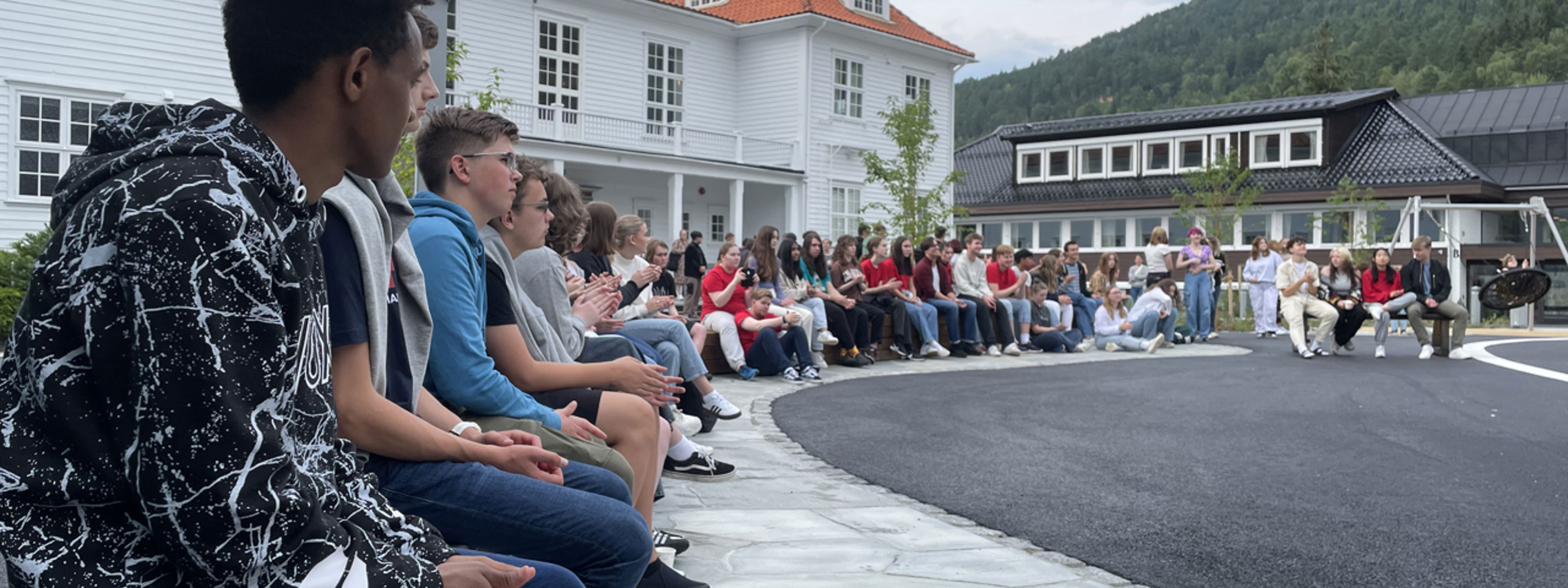 Elevar sit i u-oppsett på skuleplassen framfor gamlebygget